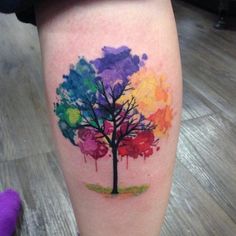 a colorful tree tattoo on the leg