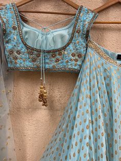 A three-piece powder blue sharmily zari lehenga set from the Priti Sahni collection. This georgette powder blue butti lehenga with pearl-zari work border detail is paired with a powder blue blouse in raw silk fabric with sequin and zardozi hand embroidery. This outfit is completed with a powder blue tulle dupatta in net material with sequin work. Light Blue Semi-stitched Lehenga With Resham Embroidery, Light Blue Floor-length Sharara With Zari Work, Fitted Light Blue Anarkali Set With Zari Work, Elegant Light Blue Choli For Festive Occasions, Elegant Light Blue Festive Choli, Light Blue Resham Embroidery Floor-length Choli, Light Blue Floor-length Choli With Resham Embroidery, Floor-length Light Blue Choli With Resham Embroidery, Floor-length Light Blue Resham Embroidered Choli