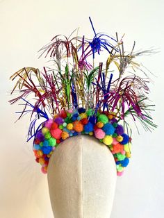 The Firework headpiece will go off with a BANG! Celebrate the New Year with this sparkling head carnival.  This colourful beauty is lovingly handmade with Pompoms and embellishments  on satin headband. The fire headpiece would be ideal for Bonfire night,  New Years Eve or a big birthday celebration. How about matching headpieces for your dinner guests  This delicate headpiece is fragile. Take care of it and it will last for many festivities.  The Bau House headpieces are handmade and unique, just like the fabulous ones that wear them. Each Firework headpiece will vary slightly in colour as they are handmade and not identical.  One size.  Not suitable for toddlers and babies.  KEEP AWAY FROM FIRE Colours may run if they get wet.  There are no returns or exchanges on this item. Fireworks Costume, Firework Costume, Fire Headpiece, New Years Eve Headband, Firework Party, Diy Carnival, Festival Headpiece, Colorful Headbands, Holiday Headbands