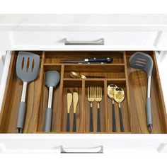 an open drawer with utensils and spoons in it