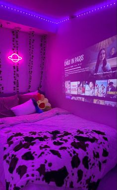 a bed in a room with purple lighting and cow print comforter on the bed