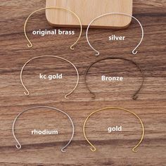 four different types of metal headbands on a wooden surface