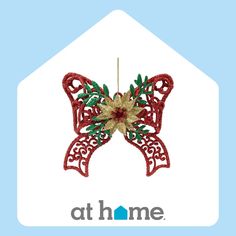 a red ornament hanging from the side of a blue and white house that says at home