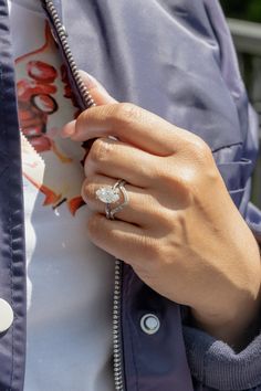 a close up of a person wearing a jacket and ring