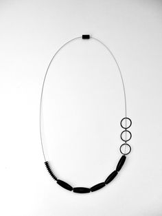 Silver Necklace - A study of balance and asymmetry, this unique necklace arranges blackstone beads, sterling silver elements, and rubber on a stainless steel cable. Modern Black Jewelry, Modern Onyx Jewelry With Black Beads, Everyday Black Single Strand Necklace, Modern Black Sterling Silver Necklace, Minimalist Black Sterling Silver Necklaces, Minimalist Black Sterling Silver Necklace, Black Sterling Silver Single Strand Jewelry, Black Single Strand Sterling Silver Jewelry, Modern Adjustable Single Strand Necklace