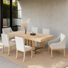 a wooden table with white chairs around it