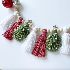 the tassels are decorated with white beads and green leafy decorations, along with a red bauble ornament