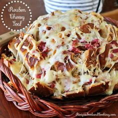 the bread is covered with cheese and bacon in a wicker basket next to a knife