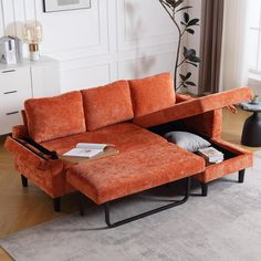 an orange sectional sofa with pull out bed and storage compartment in the middle is shown