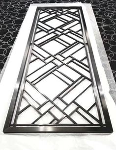 a metal grate sitting on top of a white tablecloth covered in black and white designs