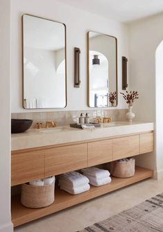 a bathroom with two sinks and three mirrors