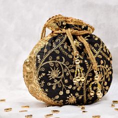 Black Potli Bag with Pearl Handle Strap With its classy zari work and a pearl handle strap all in gold this Black Potli Bag is ideal for this wedding season. Fabric Raw Silk Color Black Embroidery Zari Work in Gold Size amp Dimensions Height - 8 inWidth - 7.5 inDepth - 1.5 in Strap Pearl Handle Strap Closure Tasseled Drawstring Compartments Single compartment Care Wipe with a soft clean amp dry cloth to remove dust When not in use store it in a dust bag for longer product life Avoid liquid expos Evening Zari Work Potli Bag, Black Embroidered Bags For Festivals, Black Bags For Festivals And Gifts, Evening Potli Bag With Handwork, Handmade Potli Bag For Party And Festivals, Gold Handwork Potli Bag For Evening, Traditional Black Pouch Bag, Diwali Party Clutch Potli Bag, Festive Handmade Potli Bag For Party