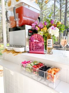 an assortment of fruits and veggies in plastic containers on a window sill