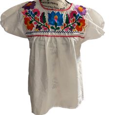 Beautiful Embroidered White Blouse, Handcrafted In Mexico Nice Colorful Embroidery 100% Cotton Womens White Blouse Size Small Measurements: Bust 20 Inches, 27 Inches Tall Spring White Embroidered Shirt, Fitted White Tops With Machine Embroidery, Fitted White Top With Machine Embroidery, White Fitted Top With Machine Embroidery, Traditional White Shirt With Floral Embroidery, White Geometric Embroidered Short Sleeve Top, White Cotton Peasant Top With Embroidered Neckline, White Machine Embroidered Blouse For Spring, White Embroidered Top With Geometric Patterns, Short Sleeve