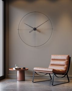 a chair and table in front of a large clock on the wall above it is a coffee table