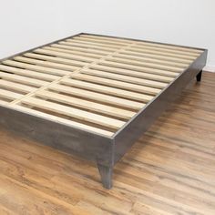 a wooden bed frame sitting on top of a hard wood floor