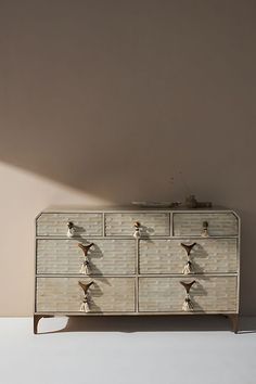 a white dresser sitting next to a wall