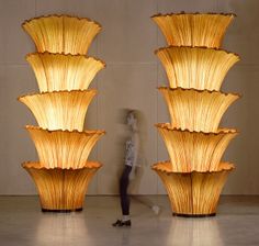 a person standing in front of two tall lamps