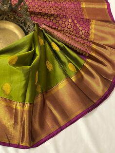 Shop for the most traditional Kanchipuram handloom silk saree in Olive green color making it look stunning and grandeur. The Kanchipuram Silk Saree enchants with gold zari motifs all over. The weave is beautifully complemented with a contrast gold zari  border. The contrast gold zari pallu with circles in series along with tassels and contrast blouse with zari border resonate with each other perfectly. This beautiful color combination saree is perfect for any occasion.  This saree is ready to wear with fall and pico done. Complimentary Fall, Edging and handmade silk tassels adorn the pallu and add more grace to it. An unstitched blouse fabric comes with the saree. Silkmark Certified  *Note: There may be minor variations in the color, the texture of the product. Color/textures show differen Green Tussar Silk Traditional Wear, Green Handloom Tussar Silk Traditional Wear, Green Paithani Silk Traditional Wear With Zari Weaving, Green Traditional Wear With Zari Weaving In Paithani Silk, Green Handloom Saree For Puja, Green Paithani Silk Traditional Wear, Green Tussar Silk Saree For Puja, Green Saree With Cutdana In Temple Jewelry Style, Green Paithani Silk Traditional Wear For Festivals