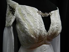 https://mariecosplayshop.com/ Wedding dress inspired by Daenerys Targaryen style custom made to your size! I made this dress inspired from the wardrobe of Daenerys! Off white color, with a blend of gold and silver embroideries on the bust and the shoulders and back. Dragon scales on the bust and the shoulders, made from dupioni silk. Beaded on the shoulders. Double layer of chiffon fabric for the long sleeves. Long train at the back, with a cord to attach the train. Open back, with an invisible zipper at the lower back. The bottom of the dress is made from chiffon fabric, pleated all arround the waist. Full lined with satin fabric. Ask me for more questions! Can be made with different colors! Please, take note that there will possibly have extra fees for plus size. White Fitted Medieval Dress For Cosplay, Daenerys Targaryen Wedding Dress, Daenerys Targaryen Blue Dress, Targaryen Wedding, Daenerys Targaryen Dress, Pale Blue Dresses, Black And Silver Dress, Magic Dress, White Pleated Skirt