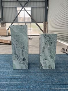 two marble blocks sitting on top of a blue rug