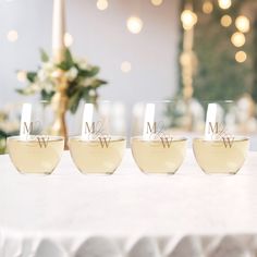 four wine glasses sitting on top of a table with the word mr and mrs etched in them