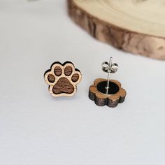 a pair of wooden earrings with a dog's paw print on the front and back