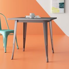 two chairs and a table in front of an orange wall with a coffee cup on it