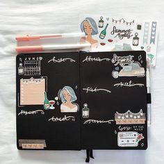 an open notebook with various stickers and writing on it, along with pens and markers