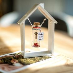 a tiny house with a key hanging from it's side on top of a table