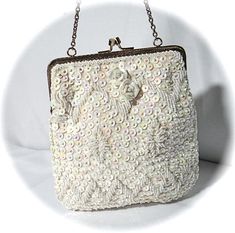 - Gorgeous creamy ivory satin beaded & sequined Vintage evening bag by Walborg...Made in Hong Kong...perfect condition!- Beautiful seed bead & iridescent sequin design on both sides..sequins and roses have an oyster shell hue..porcelain roses on front top- Twist top opening in embossed gold toned frame and gold shoulder strap measuring 10"- Handbag is tapered at top and measures 7" wide at bottom X 7" long X 1" deepTo see all of my Vintage Handbags click on this link....https://www.etsy. White Sequined Bags For Wedding, White Sequin Bag For Wedding, White Sequined Wedding Bag, Rectangular Sequined Bags For Weddings, Rectangular Sequin Bags For Weddings, Rectangular Sequin Bag For Wedding, Rectangular Sequin Bags For Wedding, Rectangular Sequined Wedding Bag, Iridescent Sequin