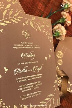 the wedding card is sitting next to some flowers