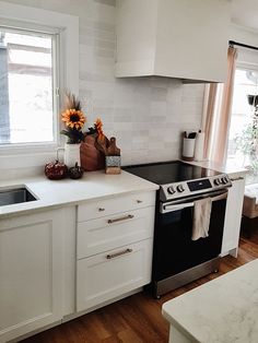 a kitchen with an oven, sink and window in the corner next to the stove