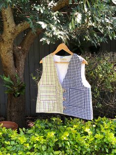 Handmade to love and to last. Completely unique and one of its kind. This unique fully lined vest is carefully and lovingly made by me, in my Sydney studio.  It is hand quilted, with a middle inner layer of 100% recycled cotton batting. Outer layer is 100% cotton multi coloured gingham - one side is a colourful purple/green/beige combination, the other a classic navy blue and white gingham. The lining is upcycled out of a thrifted white cotton table cloth that has the sweetest floral embroidery sewn at random. Button and loop closure gives it that vintage feel.  Best fit for a size S - M/L. This vest is a wider fit. Shoulder seam to bottom hem is approx  51 cm (20 inches). Perfect for layering in the cooler months, and as a statement outer piece in the warmer months. Fitted Plaid Cotton Vest, Gingham Vest, Gingham Quilt, Blue And White Gingham, Green Beige, Quilted Vest, Sweet Floral, Vest Outfits, Bright Stars