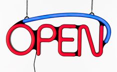 an open sign hanging from a chain on a white background with the word open written in red and blue