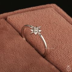 a diamond ring sitting on top of a pink blanket