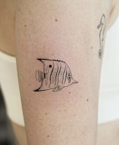 a small fish tattoo on the right arm and leg, which is drawn in black ink