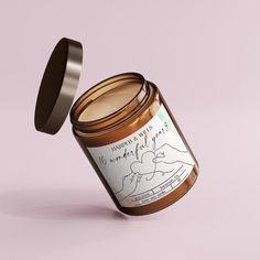 an open jar of honey on a pink background with the lid opened to reveal it's contents