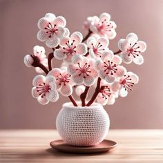 a crocheted vase filled with pink and white flowers