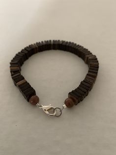 Men's 8-inch bracelet has small square beads that look wooden but are acrylic. There are 2 round beads at each end and a lobster claw clasp closure. All the men's bracelets are true-to-size. Brown Wooden Beaded Bracelets With Round Beads, Brown Wood Beaded Bracelets With Round Beads, Brown Wooden Beads For Bracelets, Brown Beaded Wood Bracelets, Brown Wooden Beaded Bracelets, Brown Wooden Beaded Bracelet, Brown Wooden Beaded Bracelets With 8mm Beads, Wooden Beaded Bracelets With Round Beads, Adjustable Wooden Bracelet With 8mm Beads