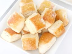 there are many pieces of bread on the white plate and one is cut into cubes