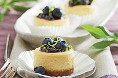 two plates with desserts on them and one has blueberries in the middle, while the other is topped with green leaves