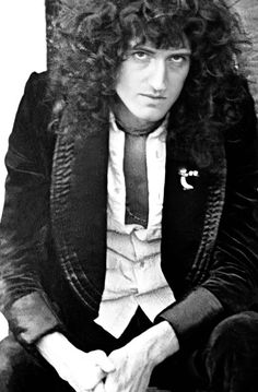 a man with long curly hair sitting down