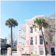 a pink building with palm trees in front of it