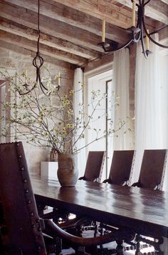 a dining room table with chairs and a vase on it