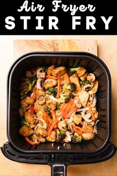 an air fryer with chicken, broccoli and carrots in it is shown