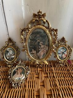 an ornately decorated wicker basket with three framed pictures on it, along with other antique items