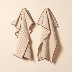 two towels hanging on the wall next to each other with one folded up and another unwrapped