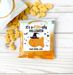 it's a fish - ally halloween treat bag on a white wooden table with candy