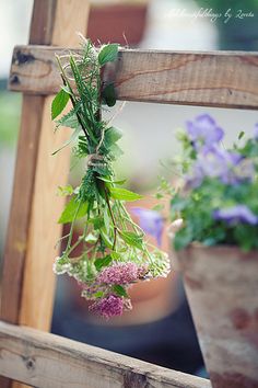 some flowers are hanging from a wooden ladder